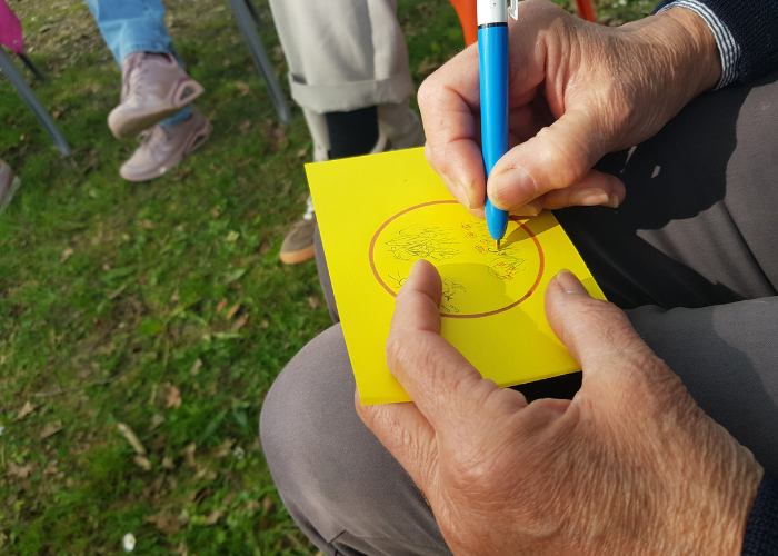 photo des mains d'une personne en train d'écrire son ressenti après les activités